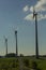 Wind turbines on green field with path. Green â€“ ecological, renewable and sustainable alternative to traditional sources of