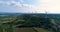 Wind turbines on a hill with fields and vines