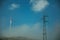 Wind turbines on hill with mist next to electric tower