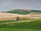 Wind turbines on the hill tops with wheat fields and barn