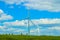 Wind turbines on the horizon of the Oklahoma Prarie under a cloudy blue sky