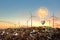 Wind turbines and lightbulb on top of garbage mountains with dramatic sunset sky background. Concept for alternative energy