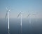 Wind turbines in motion on the ocean with blue sky