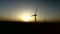 Wind turbines regenerative source of energy in the warm glow of sunset. Silhouette. Aerial survey