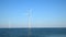 Wind turbines with rotating blades in an offshore wind park