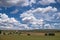 Wind turbines in rural landscape and stunning cloudy sky at the background. Environmentally friendly production of electrical