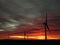 Wind turbines silhouetted against dramatic sunset sky