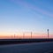 Wind turbines at sunset along highway morning commute