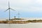 Wind Turbines and village on rocky shores of Aland Islands on sunset