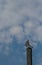 Wind vane on a chimney isolated against the blue sky