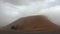 Wind whips up a sandstorm over the dunes