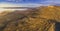 Winding dirt road in Flinders Ranges hills at sunrise.