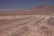 Winding endless dirt road to the nowhere of Pan de Azucar at pacific coast,  yellow sign showing left direction