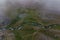 A winding mountain bubbling river filmed in a green valley from a drone