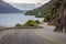 Winding mountain road lies in the foreground of a breathtaking landscape in Queenstown, New Zealand