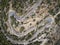 A winding mountain serpentine asphalt road. Top down aerial view