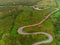 Winding narrow road on a hill in Burren, Ireland. Aerial drone view. Green fields and small trees around the pass