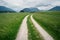 Winding path through grass meadows to villages with churches with Austrian Alps, Mieminger Plateau, Tyrol, Austria