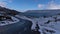 Winding paved country road on the shore of lake Kleifarvatn in KrÃ½suvÃ­k, Reykjanes, Iceland surrounded by mountains.