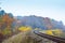 The winding railway track passing through the autumn forest_