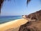 Winding road with dark cliffs, sandy beach and blue ocean in Egypt