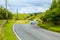 Winding road in the hills of Scotland with cars, sunny sumer day.