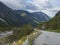 Winding road with mountain massif Trolltindene, Troll wall Trollveggen, Rauma river canyon in Romsdal valley, Norway. Blue sky