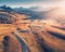 Winding road in mountain valley at sunset in autumn. Aerial view