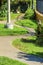 Winding S curve sidewalk in modern park in the suburban part of the city or neighborhood in late afternoon sun with