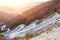 Winding serpentine road among rising to the rocky mountains. During sunset lights