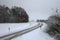 Winding slippery and snowy road  surrounded by trees covered in snow in winter