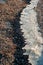 Winding strip of Ice on the shore of the Tiligul Estuary, storm emissions of algae and mollusks, Ukraine