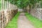 Winding walkway between decorative wooden hedges