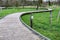 Winding wooden bridge walkway over green grass with sign: dogs on leash