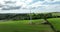 Windmill with blades against green fields of Ireland green valley 4k