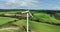 Windmill with blades against green fields of Ireland green valley 4k