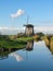 Windmill by a blue canal in the Netherlands