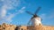Windmill of Campo de Criptana surrounded by rocks under the sunlight and a blue sky in Spain