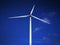 Windmill close up on blue sky and white cloud background. Wind-turbine on wind farm in rotation to generate electricity energy on