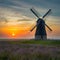 Windmill country landscape at sunset inspires with its beauty