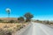 Windmill, dam, trees, corrugated gravel road between Loxton and Fraserburg