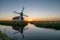 Windmill and decayed house in the dutch countryside near Leiden, Holland at sunset.