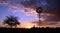 Windmill in desert sunset