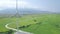 Windmill energy plant power turbine in agricultural field. Aerial view wind power generation on green field and mountain