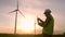 Windmill engineer watching wind turbines in operation on a laptop