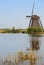 A windmill facing a house with a bird nest on the foreground bottom right corner in vertical view