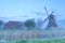 Windmill and farmhouse in fog