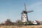 Windmill and farmhouse in a rural landscape