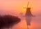 Windmill in foggy spring sunrise. Colorful spring sunrise in the wetlands.