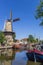Windmill and historic ships at the canal in Gouda